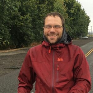 Michael O'Rourkestanding by a road way with lots of green tree's in the background.